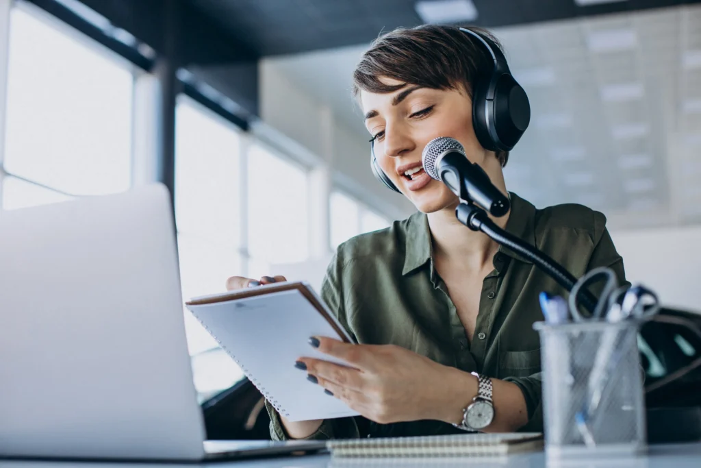 Professional interpreter speaking into microphone while reading certified translation document at desk.